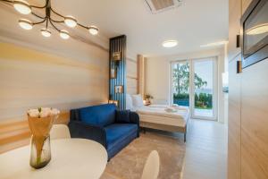 a living room with a blue couch and a bed at MyFlat Club 218 Garden Wellness Apartments in Siófok +44 photos