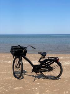 a bike with a basket parked on the beach at Ragnar Glamp Pitrags Lux in Pitragutsiyeme