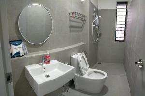 a bathroom with a sink and a toilet and a mirror at Four Leaf Clover Residence @ Crest Mount Austin JB in Johor Bahru