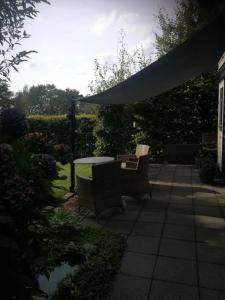 a patio with a table and chairs and an umbrella at Het Huisje in Bergen op Zoom