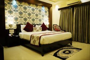 a bedroom with a large bed with red pillows at The Vaishnavi in Deoghar