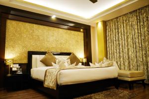 a bedroom with a large bed and a large window at The Vaishnavi in Deoghar