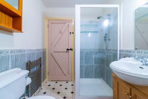 uma casa de banho com um lavatório e uma porta cor-de-rosa em Midsummer Barn em Darwen