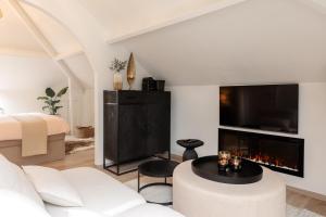 een woonkamer met een witte bank en een open haard bij B&B Maison La Belle in Zoutleeuw