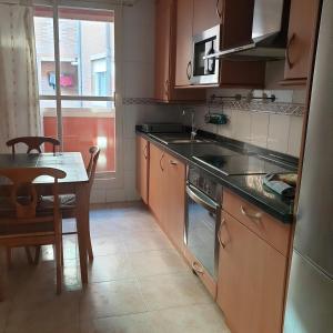 a kitchen with a table and a table and a stove at Apartamento en Lardero 4 Pax, parking incluido in Lardero