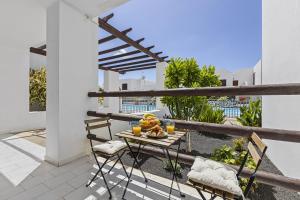 a table with a bowl of fruit on a balcony at Casa Aldea in Puerto del Carmen