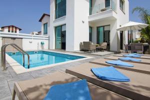 a villa with a swimming pool and patio furniture at Villa Dina in Protaras