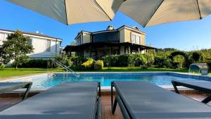 a house with a swimming pool and an umbrella at Bizim Ev in Sapanca