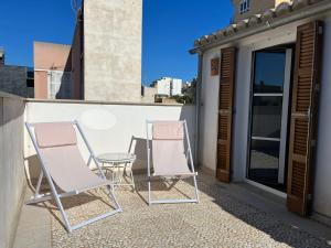 ein Paar Stühle und ein Tisch auf dem Balkon in der Unterkunft Cream homes Santa Catalina ETV in Palma de Mallorca