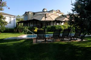 a group of chairs and an umbrella in front of a house at Bizim Ev in Sapanca +47 photos