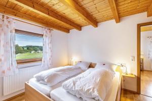 a bedroom with a bed with white sheets and a window at Ferienhaus Katrin in Bad Urach