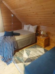 a bedroom with a bed and a night stand at Lindiki in Salaspils