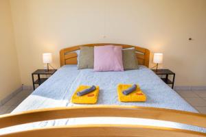 1 dormitorio con 1 cama con 2 toallas y 2 lámparas en Good connection Airport & City, en Luxemburgo