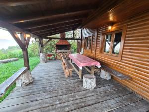 une terrasse en bois avec une table et un grill dans l'établissement Le'Klet Holiday House, à Donji Kraj