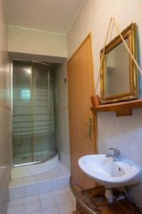 La salle de bains est pourvue d'un lavabo et d'une douche avec un miroir. dans l'établissement Le'Klet Holiday House, à Donji Kraj