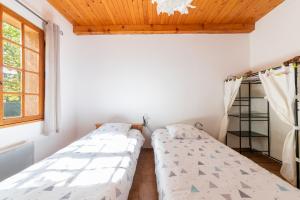 two beds in a room with a wooden ceiling at L'Oustaou Dou Verdoun - Avec grand jardin in Régusse