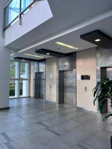 an empty lobby with doors and a potted plant at Medini Signature Ninjago Suites in Nusajaya