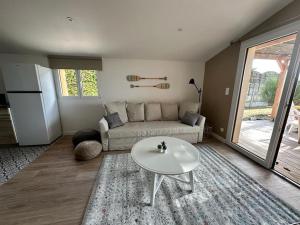 ein Wohnzimmer mit einem Sofa und einem Tisch in der Unterkunft Maison première ligne Tocade2 in Andernos-les-Bains