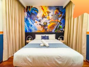 a bedroom with a large poster on the wall at Medini Signature Ninjago Suites in Nusajaya