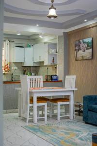 a kitchen with a table and chairs in a room at Blèu Mustard Two Bedroom in Nanyuki