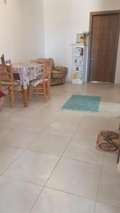 a living room with a table and chairs and a kitchen at A day at Dee's in Birżebbuġa