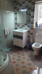 a bathroom with a sink and a toilet and a mirror at A day at Dee's in Birżebbuġa