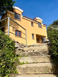 una casa amarilla con escaleras que conducen a ella en Casa Amarela - Mondim de Basto en Mondim de Basto