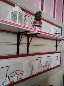 a shelf with drawings on it on a wall at Foresteria San Niccolo' 14 in Prato