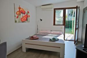 sypialnia z łóżkiem i oknem w obiekcie JASNA house with apartment w mieście Umag
