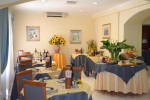 un comedor con mesas, sillas y flores en Hotel President, en Chianciano Terme