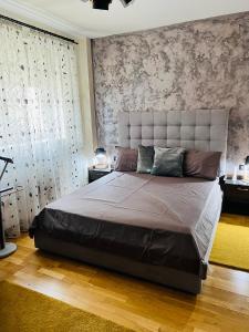 a bedroom with a large bed with a large headboard at The Ring Apartament in Timişoara
