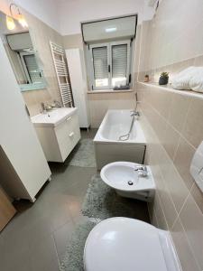 a white bathroom with a toilet and a sink at The Ring Apartament in Timişoara