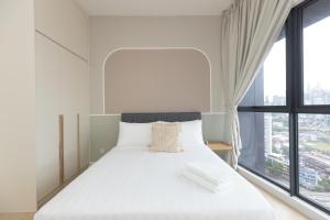 a bedroom with a large bed with a large window at Continew Residence KL CoBNB in Kuala Lumpur