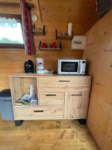 a microwave on a wooden cabinet in a tiny house at Tiny-house in Wihr-au-Val