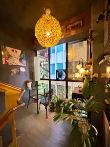ein Zimmer mit einem Tisch und einigen Pflanzen und einem Kronleuchter in der Unterkunft Taipei Triple Tiger Inn in Taipeh