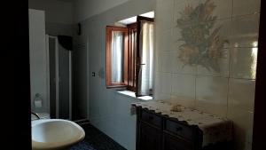 a bathroom with a sink and a toilet and a window at Da Poldino in Borgo a Buggiano
