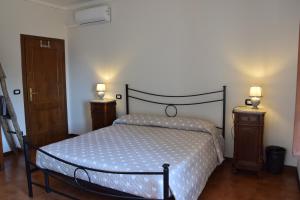 een slaapkamer met een bed met 2 nachtkastjes en 2 lampen bij Da Poldino in Borgo a Buggiano