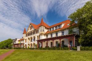 a large white building with an orange roof at Michels Haus Wilhelm-Augusta in Norderney