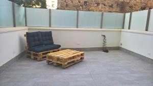 a balcony with a chair and a coffee table at Sacra Famiglia Ausonia Apartment in Palermo