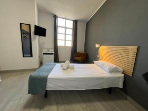 Un dormitorio con una cama blanca grande y una ventana en Pensión Cassandra, en Buzanada 33 fotos más