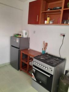 a kitchen with a stove and a refrigerator and a table at Stars paradise place in Kitengela 