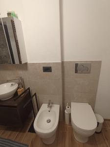 La salle de bains est pourvue de toilettes blanches et d'un lavabo. dans l'établissement Bilocale Funivie, à Breuil-Cervinia