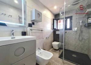 a bathroom with a shower and a sink and a toilet at Casa Hermosilla céntrica con piscina y jardín in Sanlúcar de Barrameda