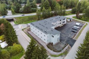 uma vista superior de um edifício branco com um parque de estacionamento em Studio Haarajoki em Järvenpää