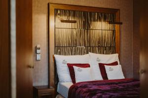 a bedroom with a bed with red and white pillows at Grape Hotel in Wrocław