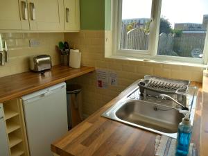 uma cozinha com um lavatório e uma janela em Seair em Rustington