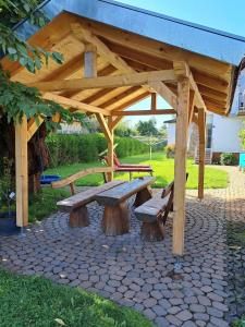 une table de pique-nique en bois et des bancs dans un parc dans l'établissement Ferienwohnung Spatzennest, à Fladungen