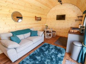 a living room with a couch in a wooden wall at The Happy Valley Pod in Chipping Norton