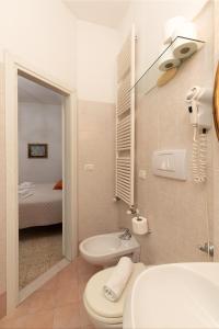 La salle de bains est pourvue de toilettes, d'un lavabo et d'un lit. dans l'établissement Ca'Spadolino, à Spello