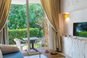 un soggiorno con tavolo e una grande finestra di Resort family apartament a Porto Istana